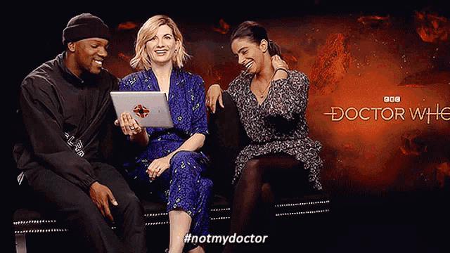 three people are sitting in front of a doctor who sign