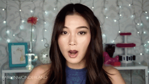 a woman with a surprised look on her face is wearing a blue top with the words pairin wonderland on the bottom