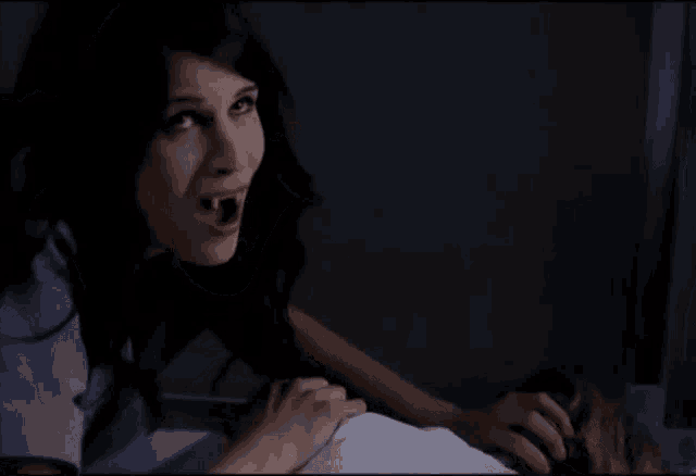 a woman with vampire teeth is holding a child