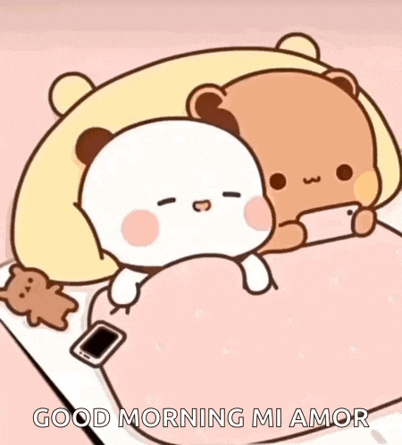 a couple of teddy bears are laying in bed with a cell phone .