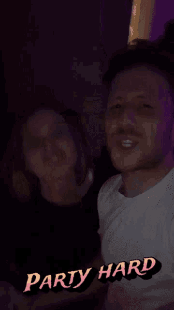 a man and a woman are standing next to each other and the words party hard are visible