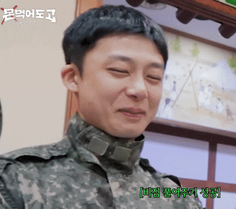 a man in a military uniform is smiling in front of a painting