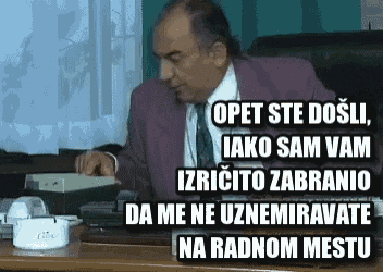 a man in a suit and tie is sitting at a desk talking on a phone ..