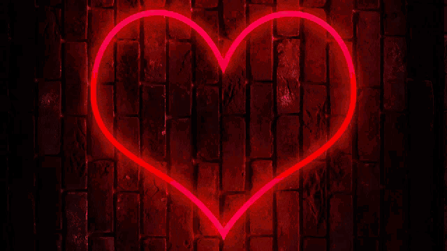 a brick wall with a red heart shaped neon sign