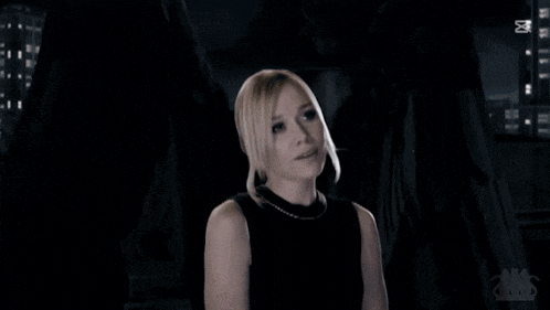 a woman in a black dress is standing in a dark room with the words zxcut on the bottom right