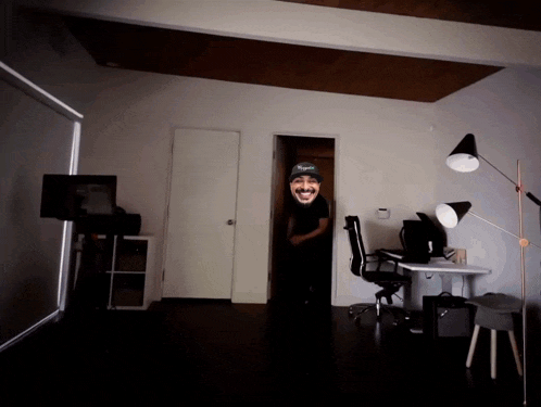 a man wearing a tigers hat is standing in a room
