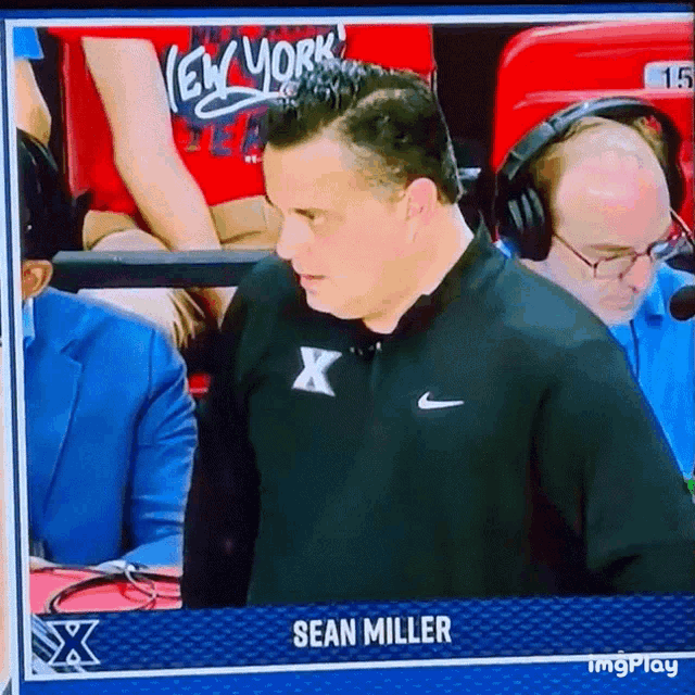 a man wearing headphones and a black shirt with the name sean miller