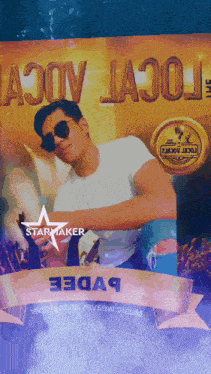 a man wearing sunglasses is standing in front of a starmaker sign