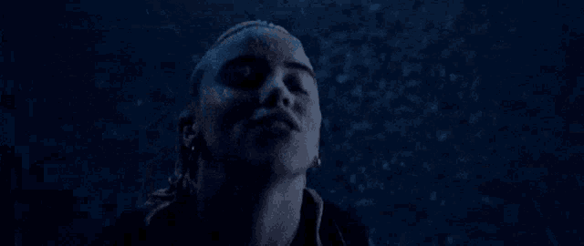 a close up of a person 's face with a blue background