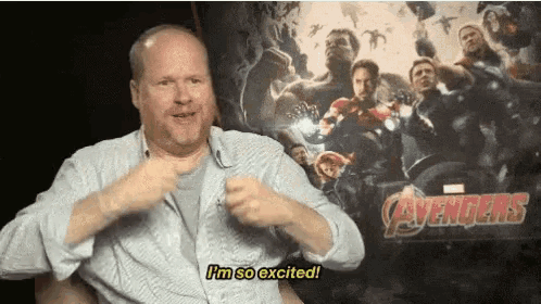 a man says i 'm so excited in front of a poster for avengers
