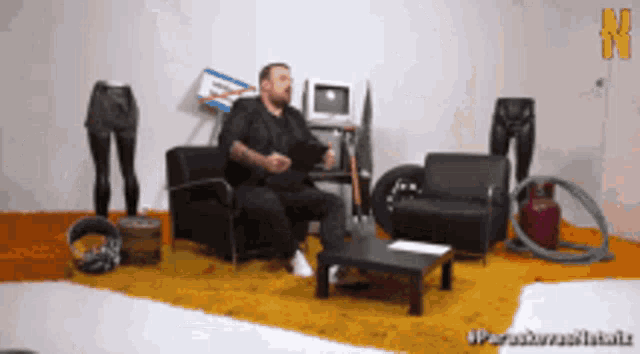 a man is sitting in a chair in a room with a table and chairs and a hula hoop