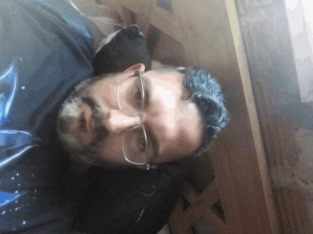 a man with glasses and a beard laying down