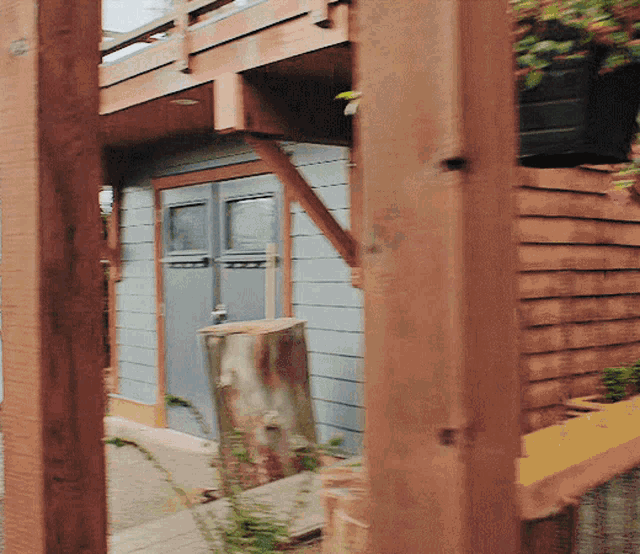 a house with a stump in front of it and a wooden fence