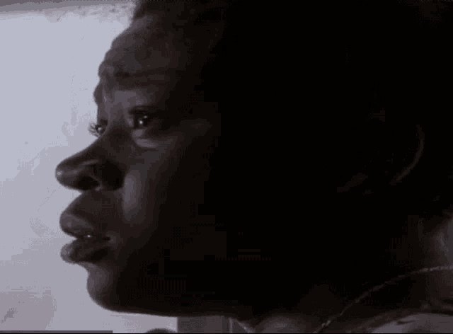 a close up of a woman 's face with a necklace around her neck