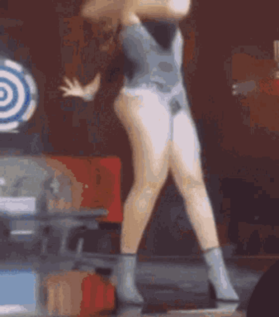 a woman is dancing on a stage in a tight bodysuit .