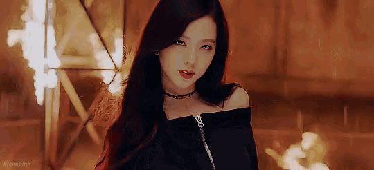a young woman with long red hair is wearing a black off the shoulder top and a choker .