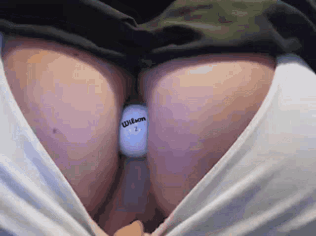a person is holding a wilson golf ball