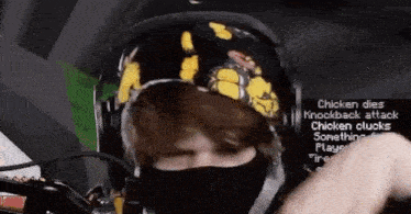 a man wearing a mask and headphones is playing a video game while wearing a bandana .