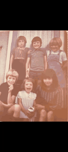 a group of children are posing for a picture and one of them is laughing