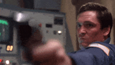 a man is pointing a gun at the camera with the number 09 in the background