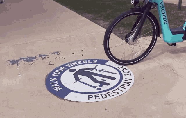 a bicycle is parked on a sidewalk with a sign that says walk your wheels pedestrian zone