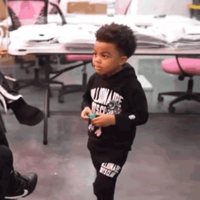 a little boy wearing a black billionaire rescue hoodie and pants