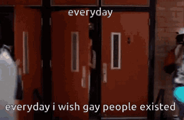 a man with a backpack is standing in front of a door with the words " everyday i wish gay people existed " written on it