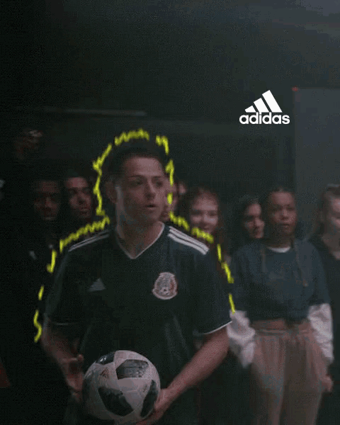 a group of people standing in front of an adidas logo