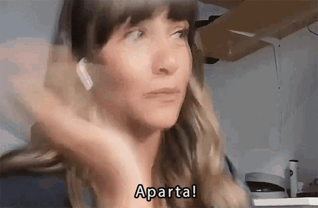 a woman wearing ear buds says aparta in a blurry video