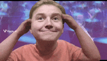 a man is making a funny face in front of a screen that says viggle.ai on it