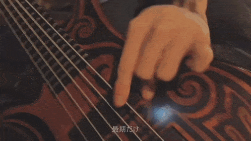 a close up of a person playing a guitar with chinese writing