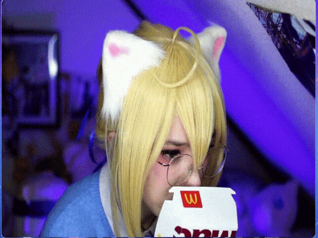 a person wearing cat ears and glasses is eating a mcdonalds box