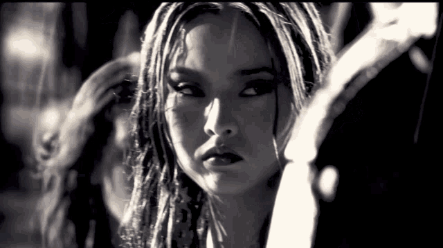 a black and white photo of a girl with dreadlocks