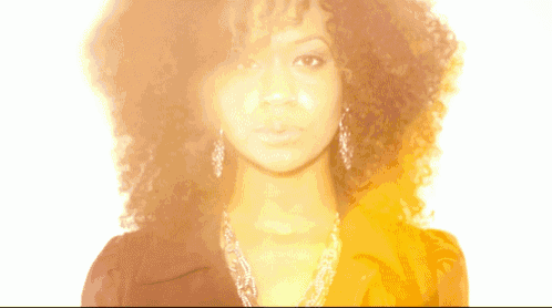 a woman with curly hair is wearing earrings and a black shirt
