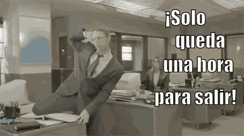 a man in a suit and tie sits on a desk with the words solo queda una hora para salir