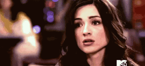 a close up of a woman 's face with a blurred background and a mtv logo .