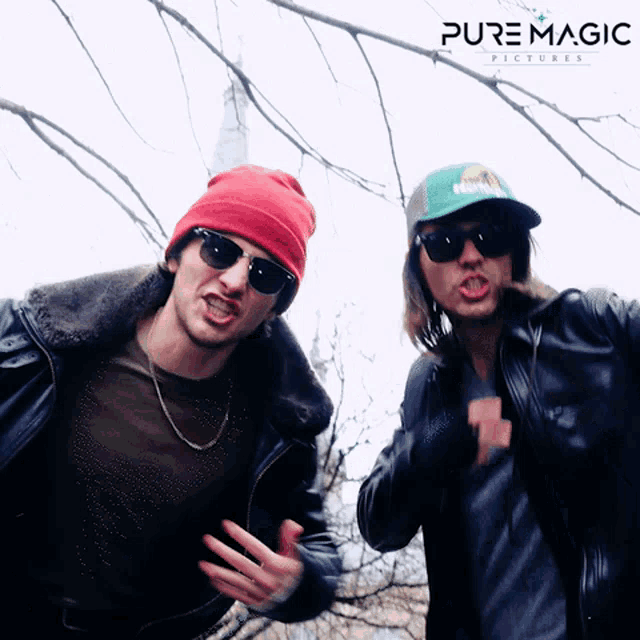 two men wearing sunglasses and hats are standing next to each other in front of a pure magic picture