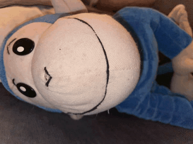 a white and blue stuffed animal with a smile on its face
