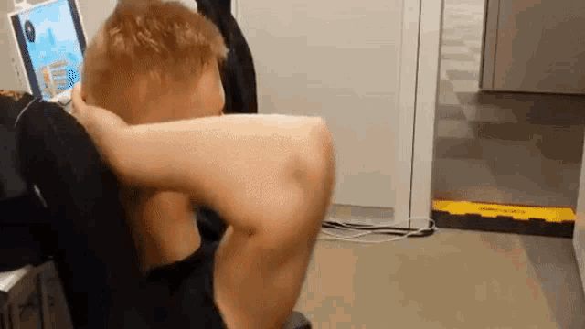 a man is doing sit ups while looking at a laptop .
