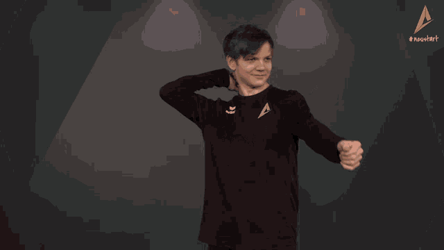 a man in a black shirt is stretching his arms
