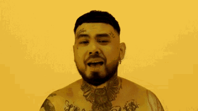 a man with a beard and tattoos on his body is singing .