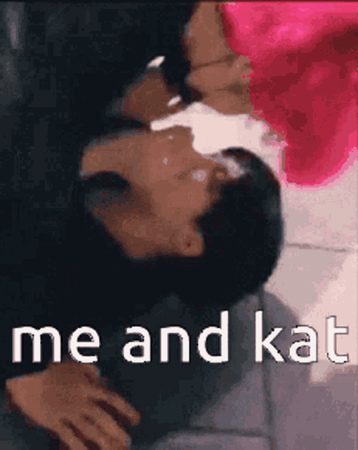 a woman with pink hair is kissing a man with black hair
