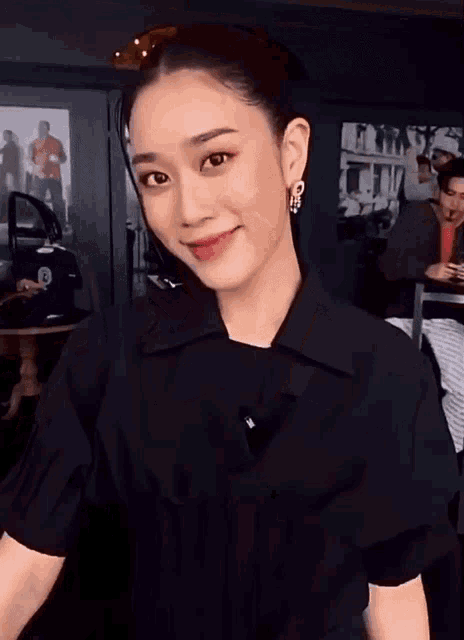 a woman wearing a black shirt with the letter b on the front