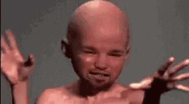 a bald man with a beard is making a funny face with his hands .