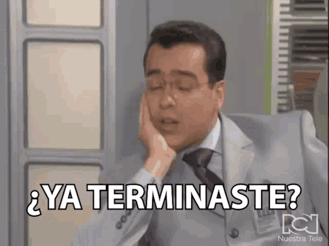 a man in a suit and tie has his hand on his chin and says ya terminaste