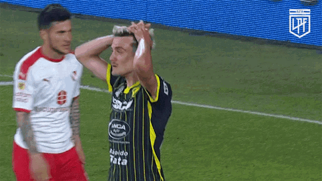 a soccer player with a bandage on his head stands on the field