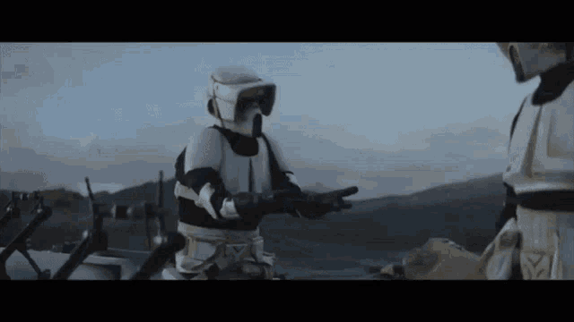 two storm trooper soldiers are standing next to each other and one is holding a gun