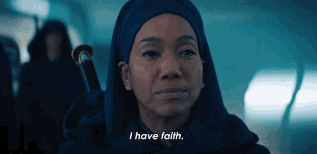 a woman in a blue hooded robe says i have faith
