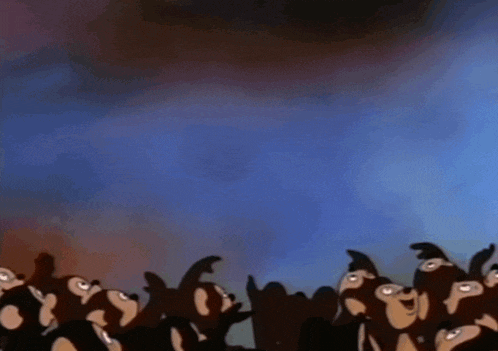 a group of monkeys are looking up at something in the sky