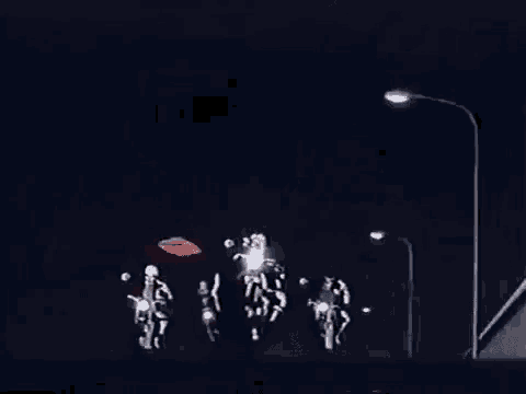 a group of people are riding motorcycles down a street at night